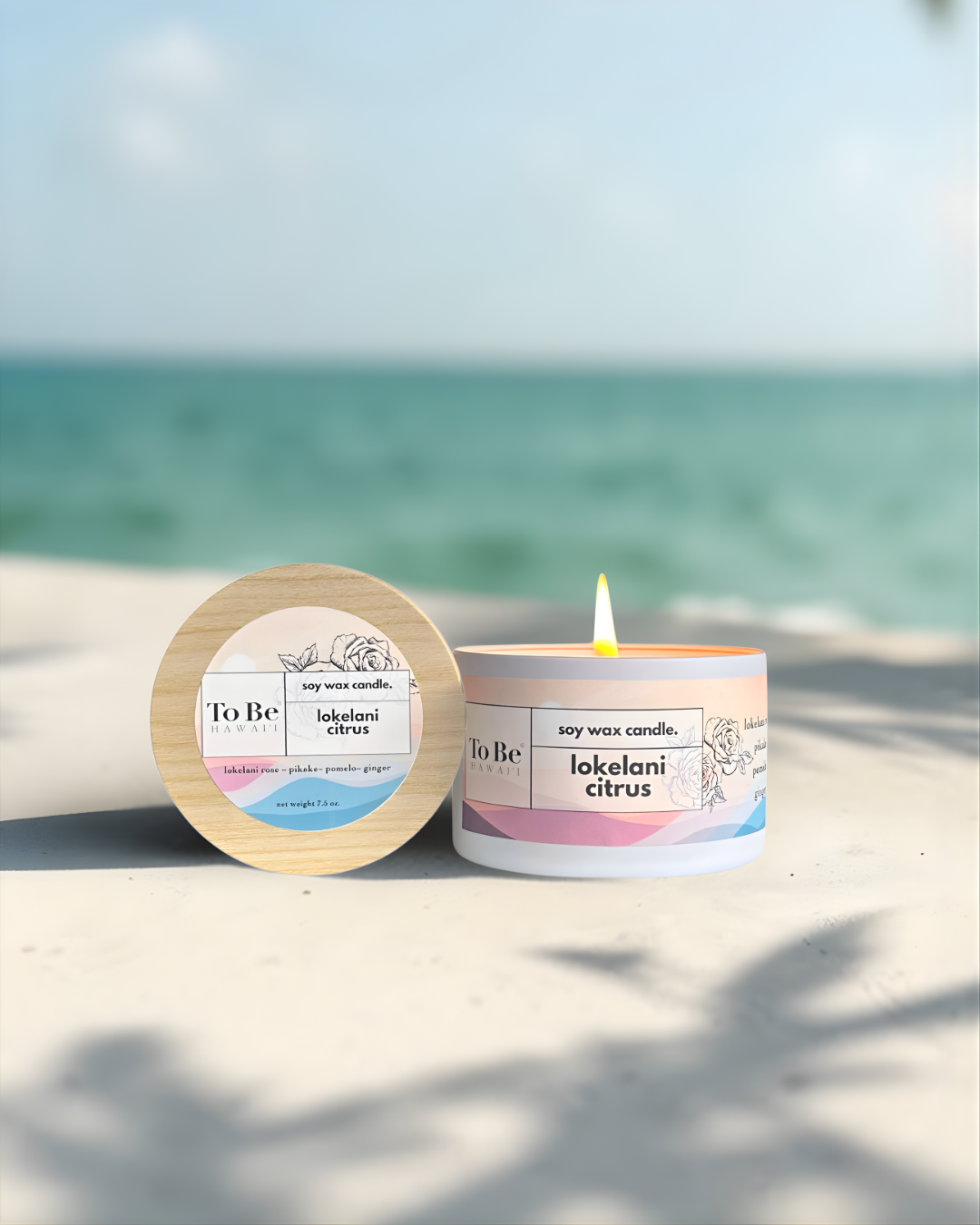 Soy wax candle with 'To Be' branding on a sandy beach with ocean view